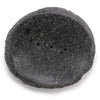 A dark gray speckled stone soap dish with rough natural edges and three small drainage holes for bathroom use