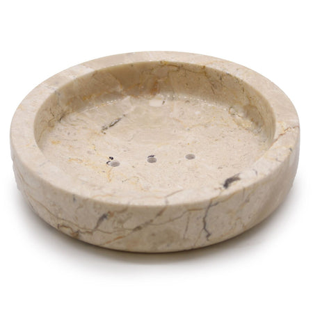 Round cream-colored honey marble soap dish with subtle veining and three drainage holes for bathroom use
