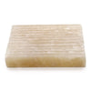 A rectangular translucent off-white honey onyx soap dish with a textured surface of parallel ridges