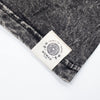 A charcoal stonewashed cotton t-shirt with black and white heathered fabric and a cream woven nomad sari label