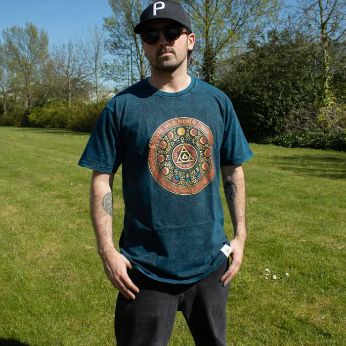 Dark teal stonewashed cotton t-shirt with stay wild moon child design of moons and geometric patterns in gold red and blue