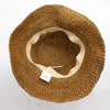 A woven tan straw sun hat with a soft beige fabric band in natural coffee color