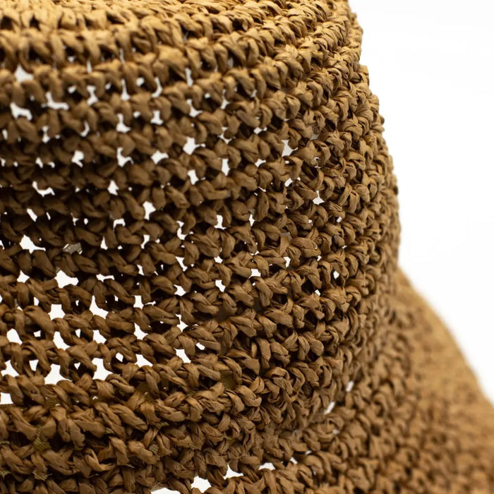 A woven straw sun hat in natural coffee tones with a textured interlaced pattern and natural brown material