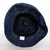 Navy blue straw sun hat made of woven straw with a black inner band and white care label at the base