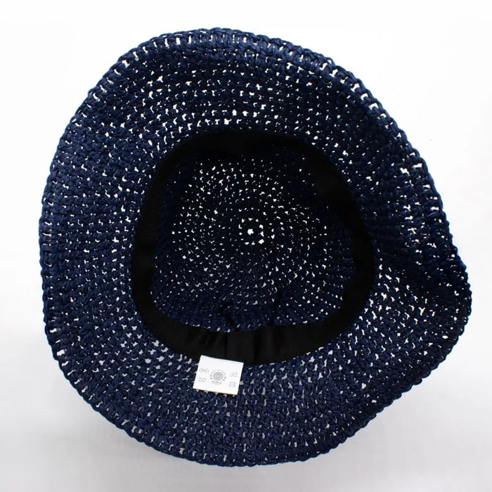 Navy blue straw sun hat made of woven straw with a black inner band and white care label at the base