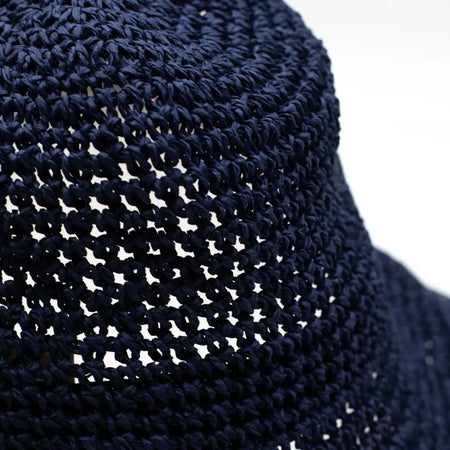 Navy blue crocheted straw sun hat with a wide brim and openwork pattern for sunny days