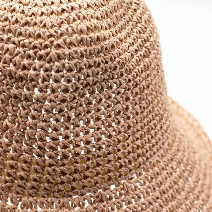 Beige woven straw sun hat with open knit texture in rose blush color made from natural straw material