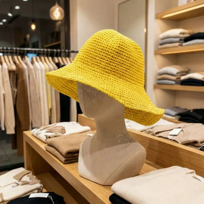 Bright yellow crocheted straw sun hat displayed on a mannequin for sun protection and style