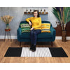 Teal velvet sofa with green and yellow pillows beside a black and grey striped indian cotton rug in a living room