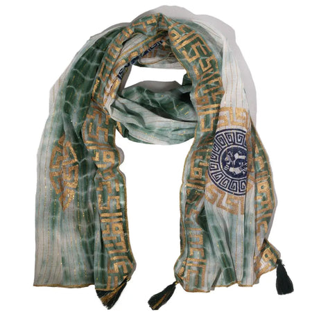 A delicate green and gold summer scarf with geometric patterns and black tassels made of lightweight fabric