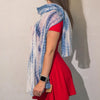 A flowing dusky blue and white tie-dye summer scarf with shimmering threads for party shine draped over a shoulder
