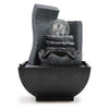Black resin tabletop water feature with layered stone tiers and a clear glass globe containing silver bubbles