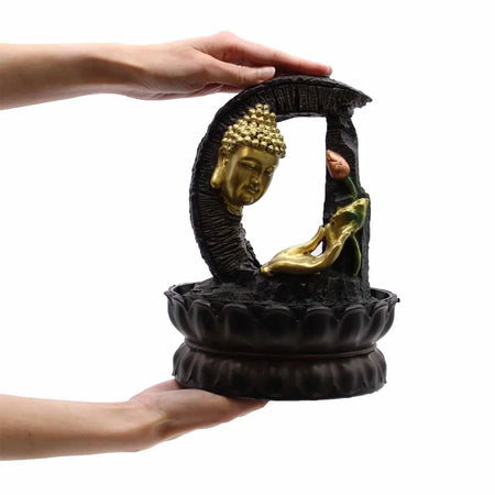 Tabletop water feature showing a golden buddha head fountain with black resin base and lotus design