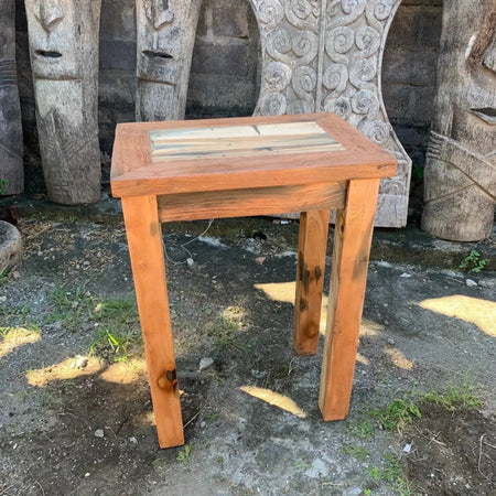 Tall bar style table with a patchwork top of reclaimed wood planks and warm orange brown finish for home decor