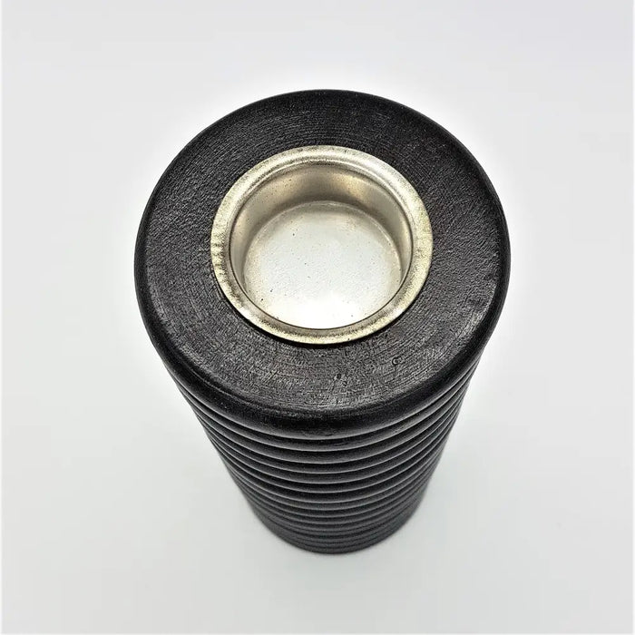 Black rubber-coated threaded bolt with silver head next to a tall ribbed wooden tealight holder