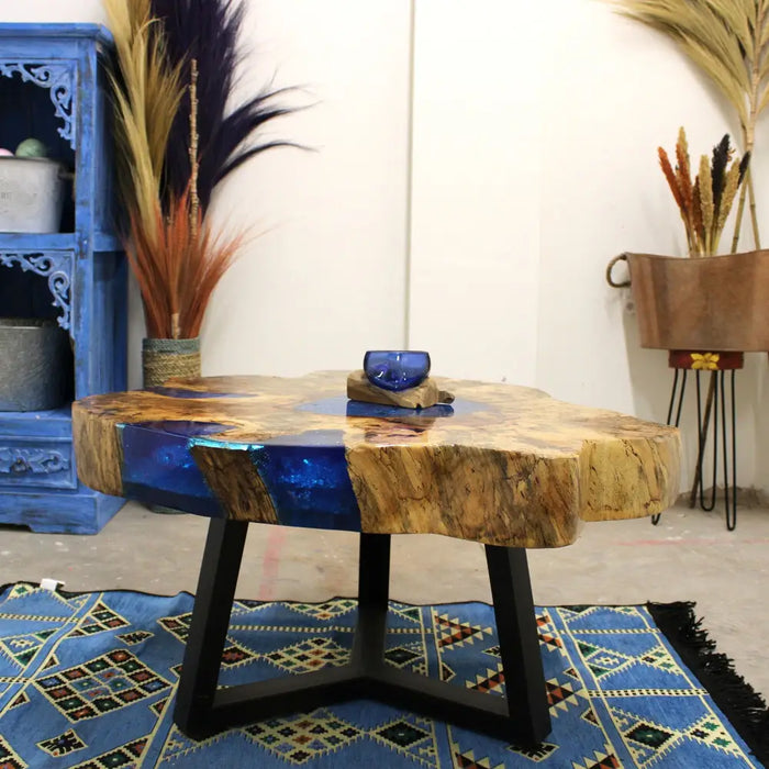 Rustic tamarind wood coffee table with a natural top set in blue resin and black metal legs