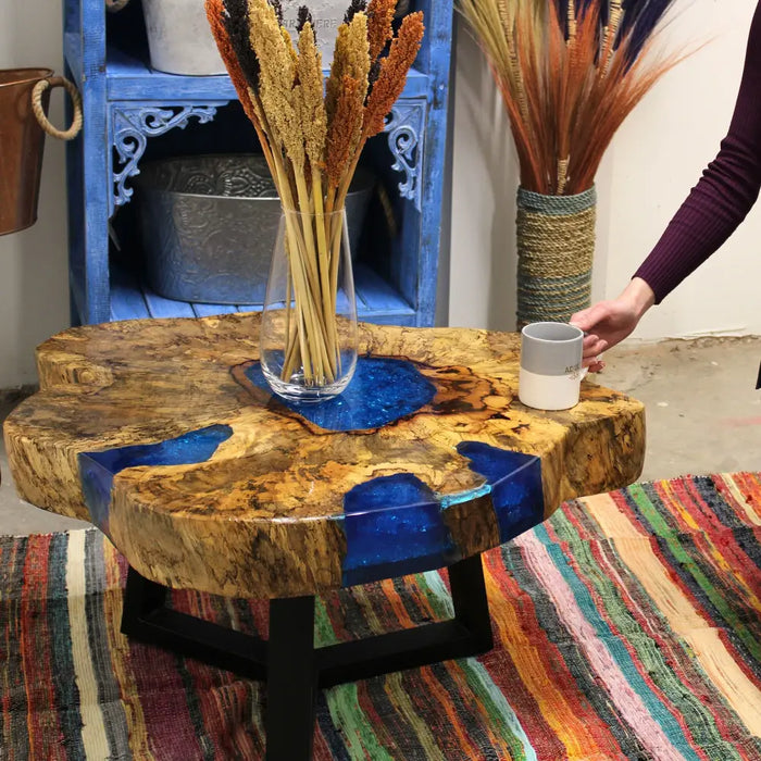 Tamarind wood coffee table with natural slab top and sky blue resin inlays on black metal legs