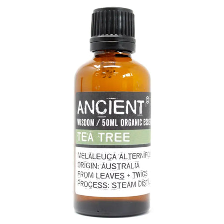 Amber glass bottle with black cap labeled ancient wisdom tea tree oil 50ml melaleuca alternifolia organic essential oil