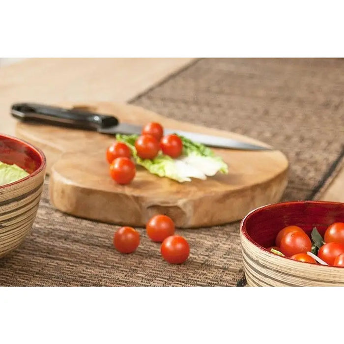 Wooden teak chopping board 40cm with natural wood grain and rounded edges with a knife resting on it