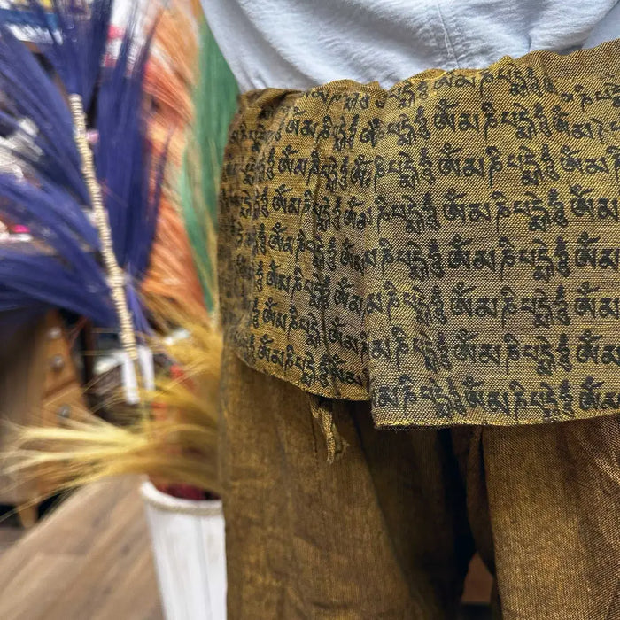 Golden fabric belt with black tibetan script woven on cotton thai fisherman pants mandala mantra orange