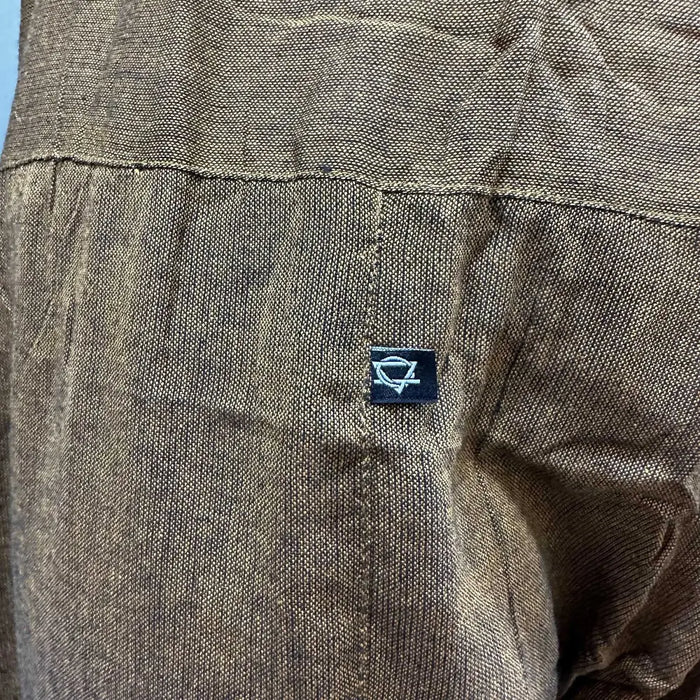 Brown textured cotton shirt with small black label and white logo shown with orange thai fisherman pants mandala mantra