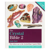 The crystal bible 2 by Judy Hall is a hardcover book with a white cover featuring colorful crystals and purple text