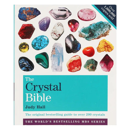The crystal bible by judy hall is a hardcover book with a white cover, teal title text, and colorful crystal images
