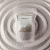 The Window, Milford Haven Azure Noir warm grey fragranced candle sand in a 300g pouch with four cotton wicks.