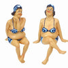 The Window, Milford Haven resin bathing beauties shelf-sitter figurines in blue bikinis with crossed legs and ankles.