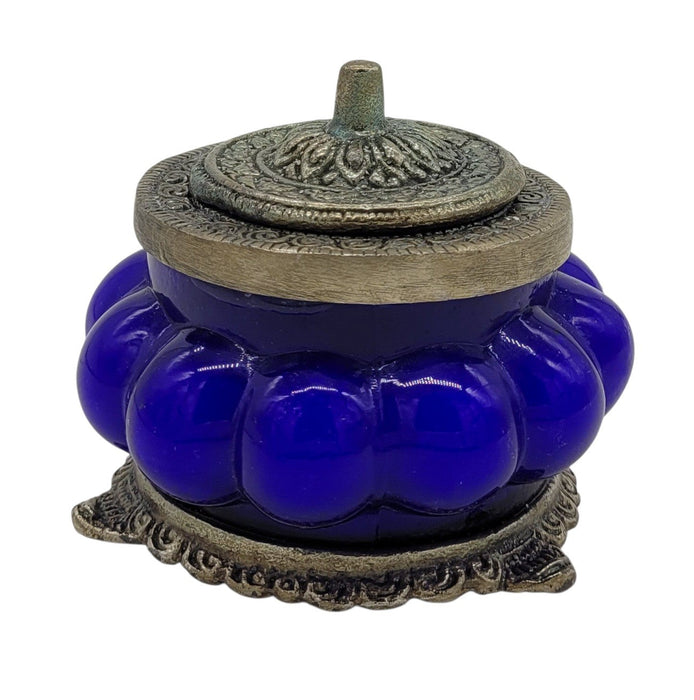 The Window, Milford Haven Nag Champa scented candle in a blue pumpkin-shaped glass jar with ornate white metal lid.