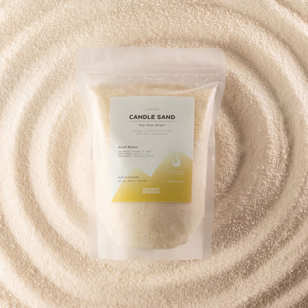 The Window, Milford Haven Blush Bloom fragranced candle sand in a 300g pouch, surrounded by golden wax granules.