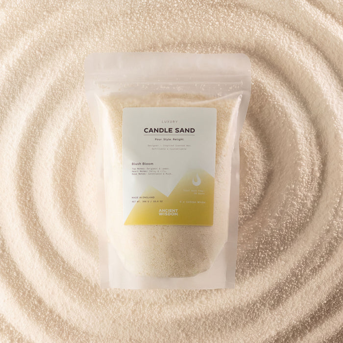 The Window, Milford Haven Blush Bloom fragranced candle sand in a 300g pouch, surrounded by golden wax granules.
