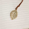 The Window, Milford Haven notebook featuring a brass-coloured leaf bookmark on lined paper pages.