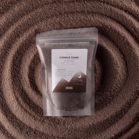 The Window, Milford Haven Millionaire Gold chocolate brown candle sand in a pouch set against a textured sand spiral.