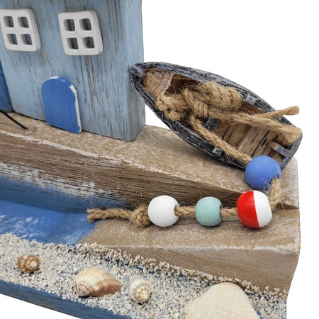 The Window, Milford Haven wooden coastal ornament featuring a blue cottage, miniature boat, and real seashells.
