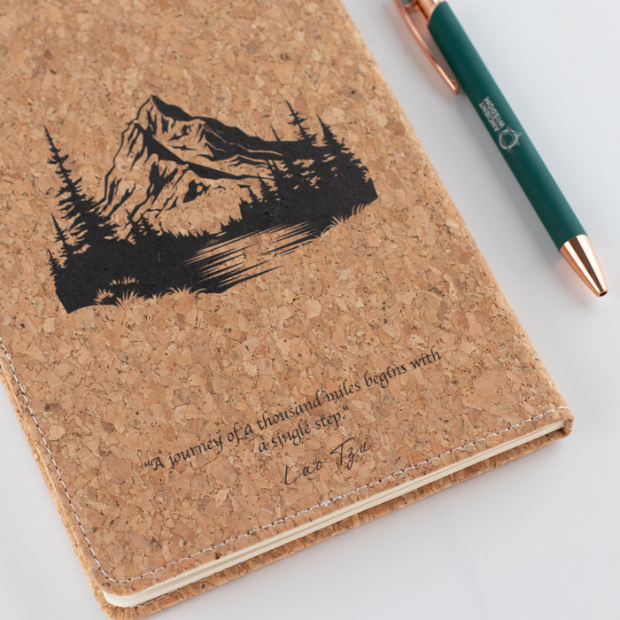 The Window, Milford Haven cork leather-effect notebook with a mountain design and Lao Tsu quote, featuring a green pen.