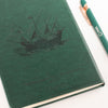 The Window, Milford Haven green leather-effect notebook featuring a galleon ship embossment and Sun Tzu quote.