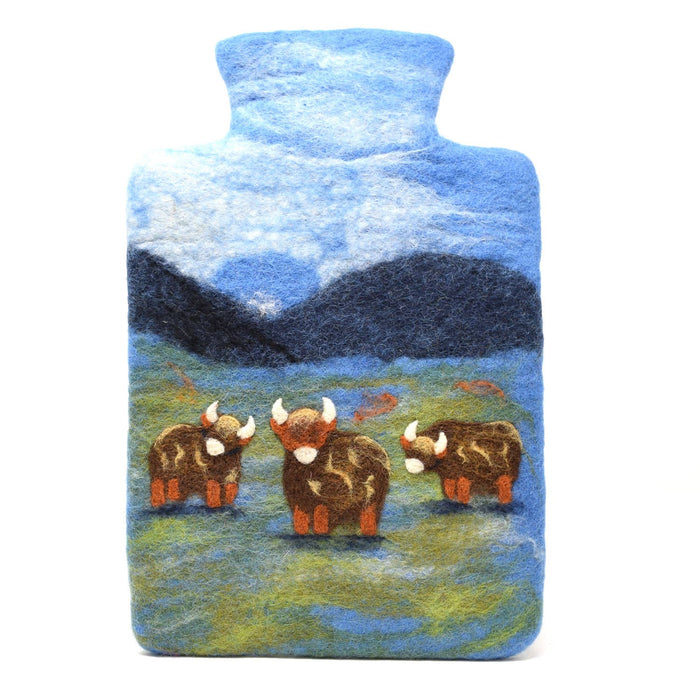 The Window, Milford Haven handmade wool felt hot water bottle featuring a scenic Highland Cow design on a blue field.