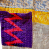 The Window, Milford Haven Kantha cotton overalls featuring a purple pocket with pink zig-zag pattern and yellow trim.
