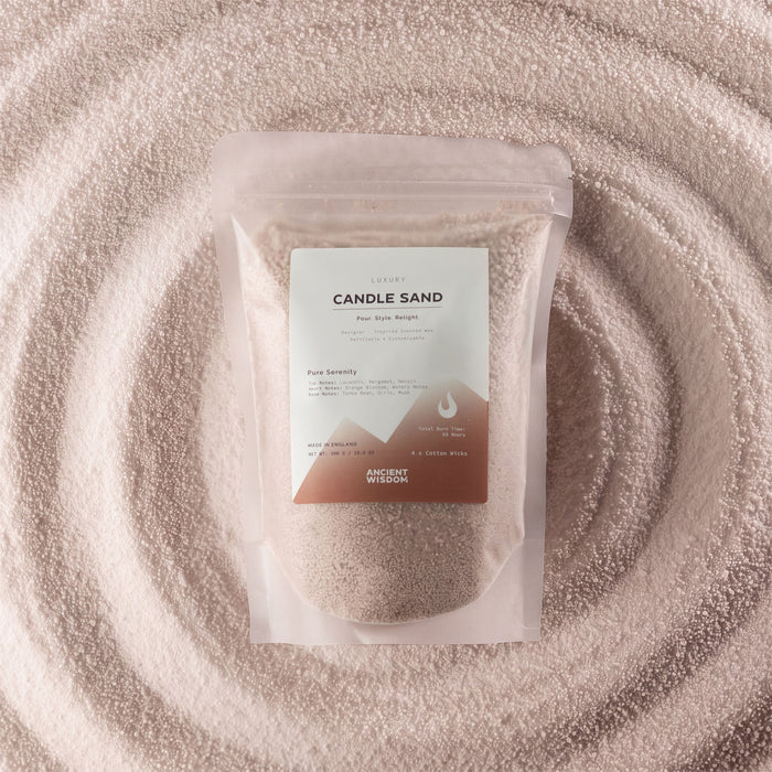 The Window, Milford Haven latte beige Pure Serenity candle sand in a pouch surrounded by a circular pattern of wax beads