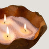 The Window, Milford Haven Pure Serenity latte beige candle sand burning with three wicks in a rustic wooden bowl.