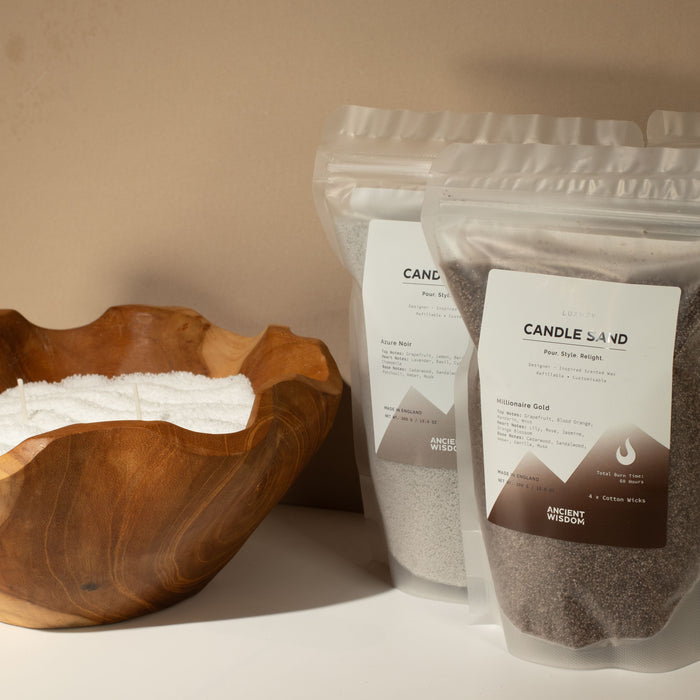 The Window, Milford Haven Crimson Crystal mocha brown candle sand in a pouch next to a wooden bowl of candle sand.