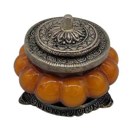 The Window, Milford Haven Patchouli Amber scented soy candle in an orange pumpkin-shaped glass jar with metal lid.
