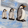 The Window, Milford Haven handmade wool felt hot water bottle cover featuring a cute penguin family on a blue background