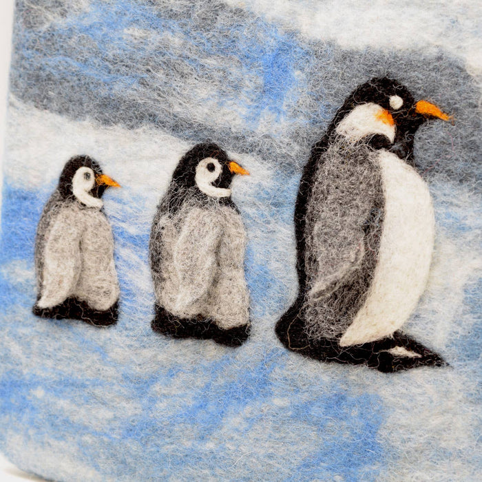 The Window, Milford Haven handmade wool felt hot water bottle cover featuring a cute penguin family on a blue background