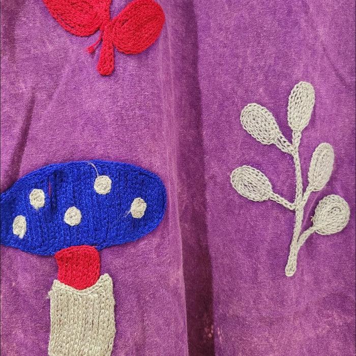 The Window, Milford Haven purple cotton tunic dress featuring vibrant embroidered toadstool and leaf motifs.