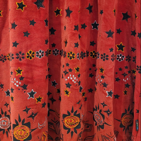 The Window, Milford Haven red velour tunic dress featuring embroidered stars, flowers, and sun motifs.