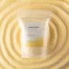 The Window, Milford Haven Regent Polo cream candle sand in a 300g pouch displayed on a bed of loose wax granules.