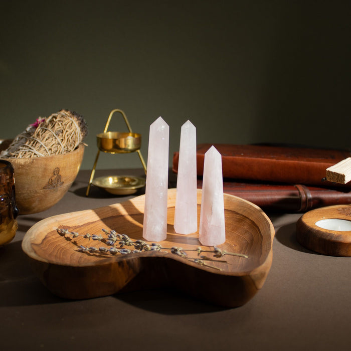 The Window, Milford Haven rose quartz six-face obelisk points displayed on a wooden tray with dried lavender.
