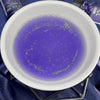 The Window, Milford Haven Sagittarius zodiac fragrance oil in a white ceramic burner with purple liquid and bio glitter